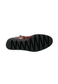 Zapato de cuero marrón con una suela de goma negra texturizada, que presenta patrones de zigzag para tracción y un detalle de cremallera lateral.