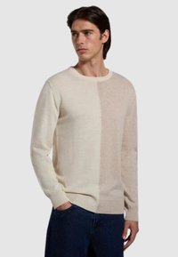 Maglione lavorato a maglia beige e crema con collo a giro, caratterizzato da un design color-block. Texture liscia, maniche lunghe e polsini a costine.