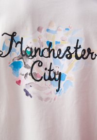 Bílý bavlněný tričko s velkým černým psaným textem "Manchester City" obklopené abstraktním akvarelem v modré a růžové.
