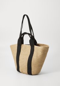 Woven straw tote bag with black fabric straps, featuring a wide base, curved top, and textured surface. Compact and lightweight design.