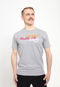 Šedé bavlněné tričko s barevným grafickým potiskem "JT Racing" obsahující horizontální pruhy v růžové, oranžové a žluté barvě. Krátké rukávy a kulatý výstřih.