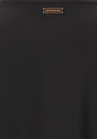 Zwart sporttop van gladde stof met een ronde hals. Voorzien van een klein metallic merklabel nabij de schouder.