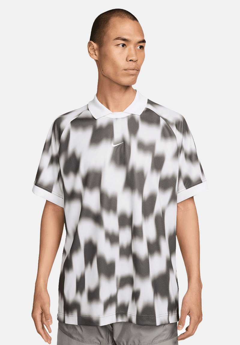 Mannen polo shirt in het wit met een zwart abstract patroon, voorzien van een klassieke kraag, korte mouwen en een Nike-logo op de borst.