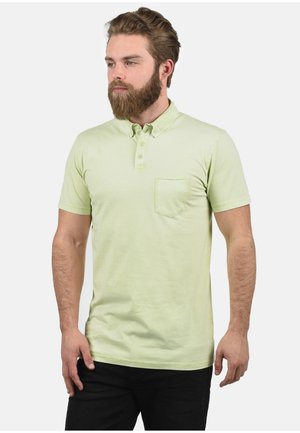 Polo met korte mouwen van lichtgroene stof, voorzien van een knoopsluiting, kraag en een borstzak. Soepele textuur, casual pasvorm.