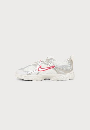 Witte en zilveren sportschoen met rode Nike-swoosh, mesh en synthetische bovenkant, dikke zool en trekbandje aan de hiel, zijaanzicht.