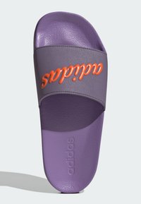 Fioletowe klapki z teksturowanej powierzchni. Posiadają szeroki szary pasek z napisem "adidas" w kolorze pomarańczowym. Regulowane dopasowanie z wyściółką na podeszewce.