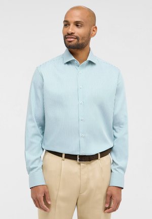 Chemise rayée bleu clair à manches longues avec fermeture à boutons, assortie à un pantalon beige et une ceinture marron foncé. Texture lisse et coupe ajustée.