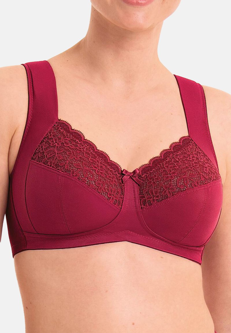 Soutien-gorge bordeaux avec un détail en dentelle sur le dessus, des bretelles larges et un accent en nœud. Fabriqué en tissu lisse, il présente une conception de soutien-gorge avec armatures.