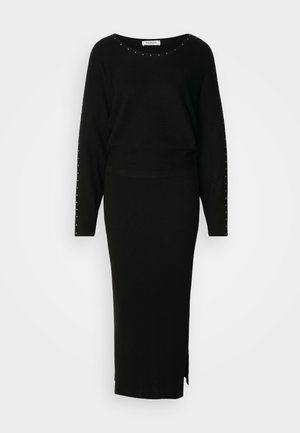 Ensemble en tricot noir en deux pièces composé d'un haut à manches longues avec des embellissements en studs et d'une jupe maxi ajustée à côtes avec une fente sur le côté.