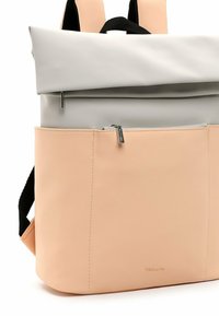 Rucksack in Grau und Pfirsich mit einem Roll-Top-Design, ausgestattet mit einer Vordertasche mit Reißverschluss, schwarzen Trägern und einer glatten, matten Oberfläche.