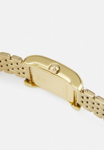 Montre-bracelet en métal doré avec un boîtier rectangulaire, un bracelet texturé et une couronne striée sur fond blanc.
