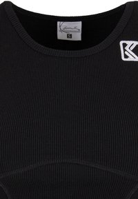 Mustvalge elastne tank top ümmarguse kaelusega. Vasakul küljel on väike valge logo. Valmistatud venivast kangast, mis tagab tiheda istuvuse.
