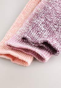 Drie gebreide stoffen scrunchies in tinten roze en paars, met een gestructureerd patroon met gemengde kleuren en zacht, rekbaar materiaal.