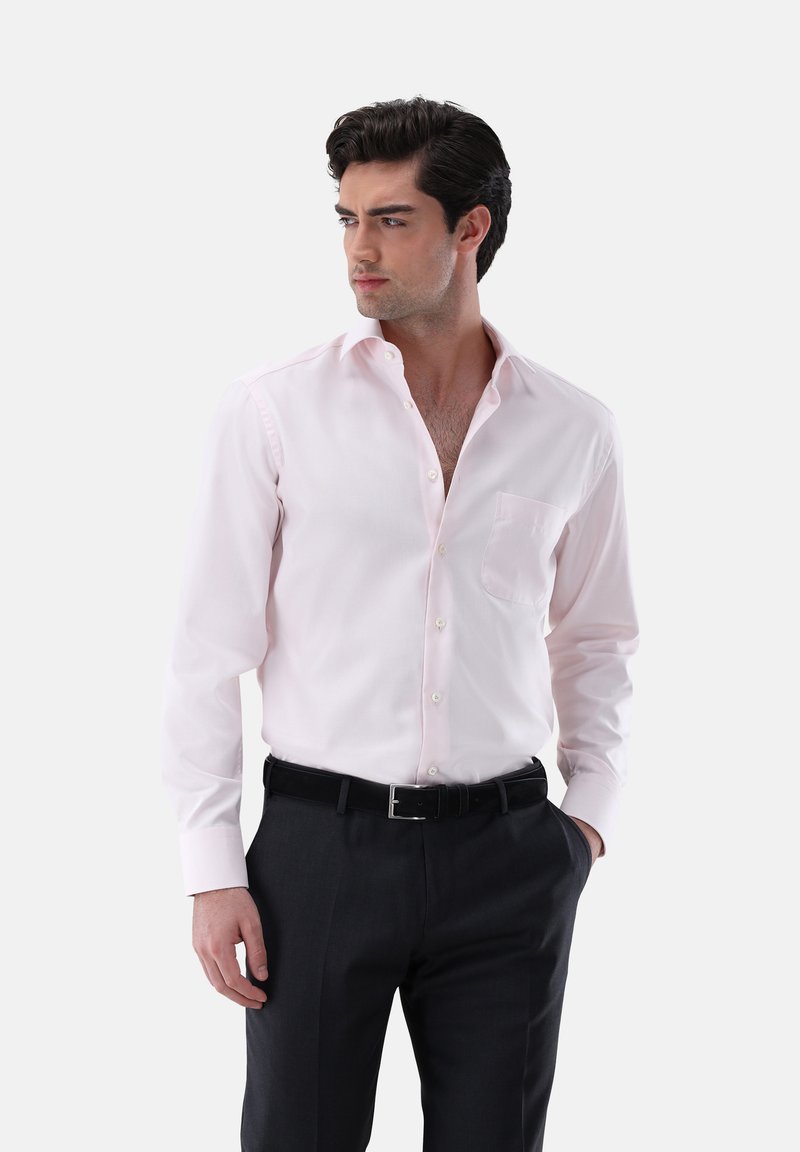 Camicia col colore rosa chiaro, con colletto e maniche lunghe con polsini a bottone, una tasca sul petto, abbinata a pantaloni scuri in tessuto texture, design slim fit.