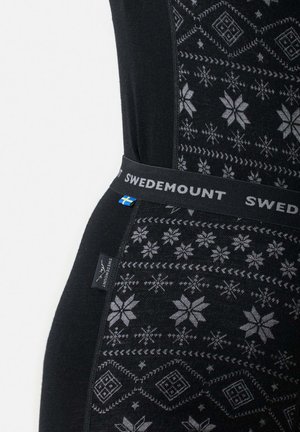 Svarta termoleggings med ett grått snöflingemönster, med en mjuk midjeband märkt "SWEDEMOUNT" och en etikett på sidan.