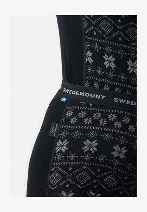 Musta lämpöleggingit, joissa on harmaa lumihiutale-kuvio, varustettuna pehmeällä vyötäröllä, johon on merkitty "SWEDEMOUNT" sekä sivutunnuksella.