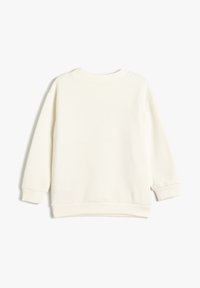 Kremowy sweatshirt z okrągłym dekoltem, długimi rękawami, ściągaczami przy mankietach i u dołu, gładką teksturą tkaniny, bez widocznych elementów wzorniczych.