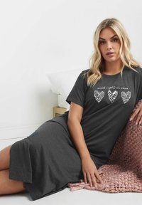 Grå, kortärmad nattklänning med avslappnad passform, som har vita hjärt-grafiker och texten "vild natt in xoxo." Mjuk material och knälång.