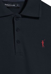 Polo náutico de tejido texturizado, con cierre de tres botones y un logotipo bordado en rojo de un golfista en el lado izquierdo del pecho.