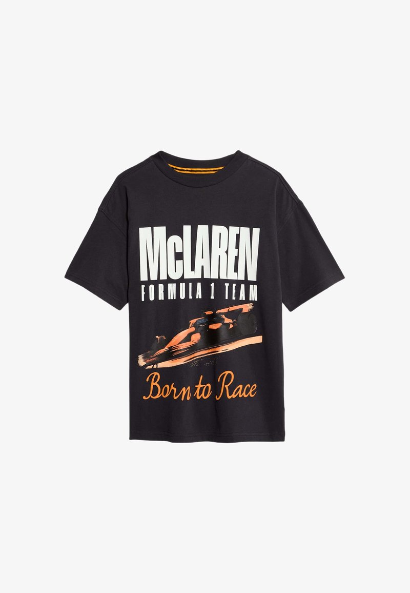 Černé bavlněné tričko s bílým textem "McLAREN FORMULA 1 TEAM" a grafickým ztvárněním oranžového auta s nápisem "Born to Race" v oranžovém písmu.