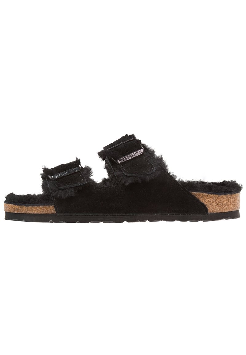 Sandali neri foderati in pelliccia con due cinturini regolabili, suola in sughero per il comfort e suola in gomma per la trazione. Morbida texture e design informale.