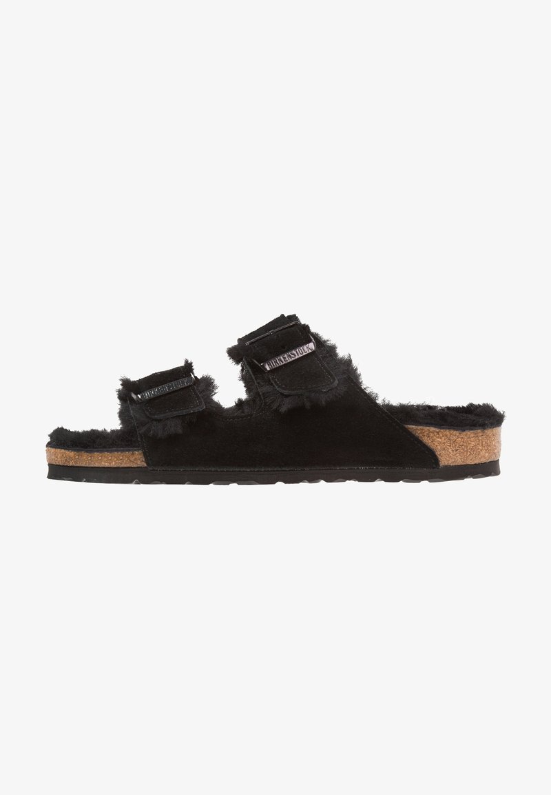 Schwarze, mit Fell gefütterte Sandalen mit zwei verstellbaren Riemen, Korkfußbett für Komfort und Gummisohle für Halt. Weiche Textur und lässiges Design.