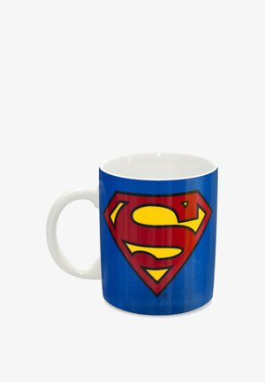 Weißer Keramikbecher mit blauem Hintergrund, der auf einer Seite ein großes rotes und gelbes Superman-Logo zeigt. Glatte Oberfläche, runde Form.