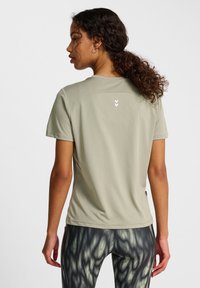 Ljusgrön träningströja med korta ärmar och en strukturerad tyg. Har en liten vit design på övre delen av ryggen.