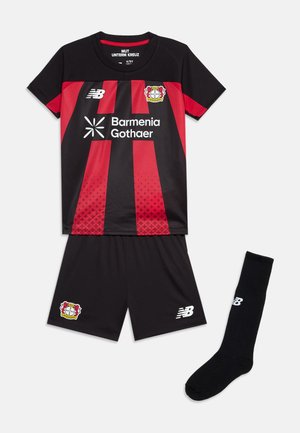 Tenue de football noir et rouge du Bayer Leverkusen avec maillot à manches courtes, short noir et une chaussette noire avec le logo blanc New Balance.