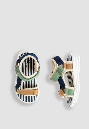 Zilas un zaļš rakstains bērnu sandales ar svītrainu iekšējo zoli, regulējamām siksnām un elastīgu balto gumijas zoli.