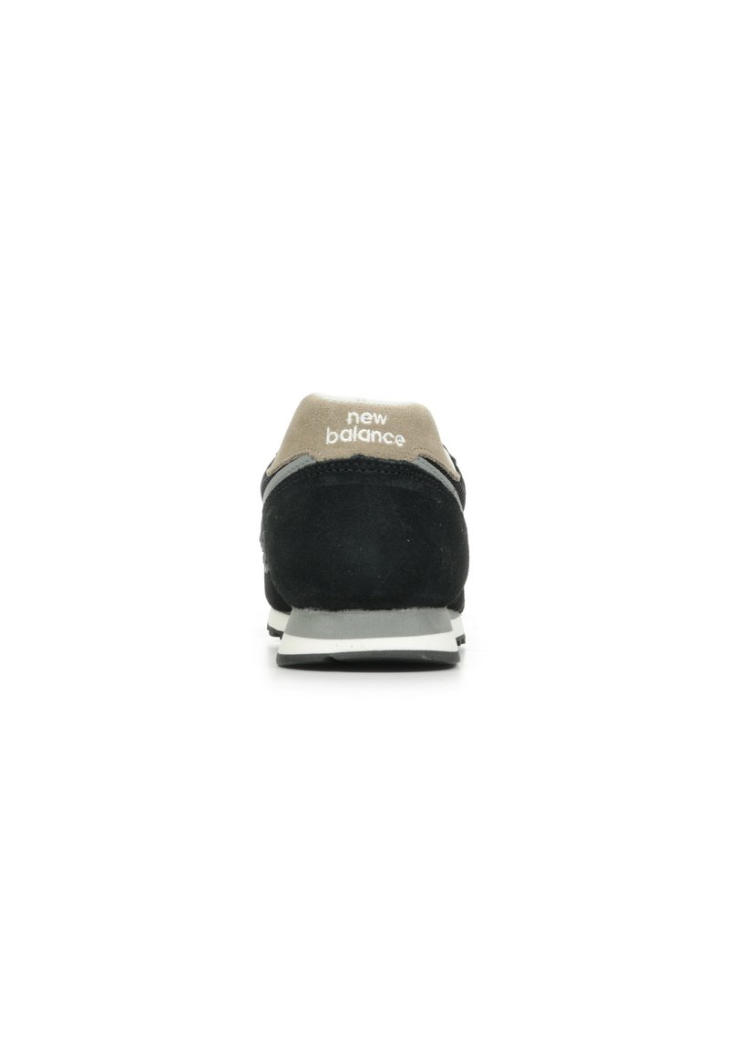 Zapatilla de ante negra con un talón de malla gris, logo blanco en el talón y una suela de goma gris. Diseño delgado y aerodinámico con acentos en contraste.