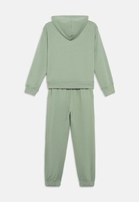 Conjunto de sweatshirt e calças de fato verdes feitos de um tecido suave. Apresenta capuz, punhos canelados e um cós elástico para maior conforto.