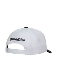 Stražnji pogled na bijelu snapback kapu s crnim izvezenim logom "Mitchell & Ness" i crnim gumbom na vrhu.
