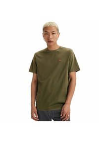 Camiseta de algodón verde oliva con cuello redondo, mangas cortas y un pequeño logo rojo de Levi's en el pecho izquierdo. Textura suave, corte relajado.