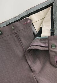 Skræddersyede bukser i et mauve hørmønster. Har lynlås, to knapper og en kontrasterende inderside med subtile detaljer.