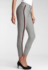 Grå rutiga tighta byxor med röda och svarta sidostråkar, med en elegant design, hög midja och ankellängd. Slät tygkänsla.