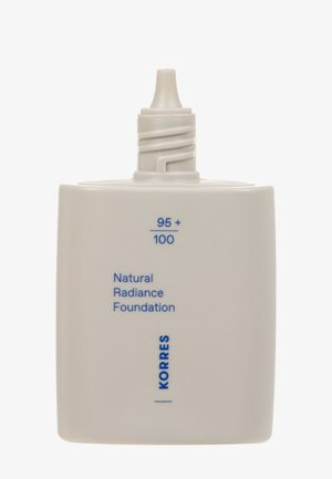 Natural Radiance Foundation in a matte white plastic bottle, featuring a tapered nozzle and blue text reading "95 + 100" and "KORRES."