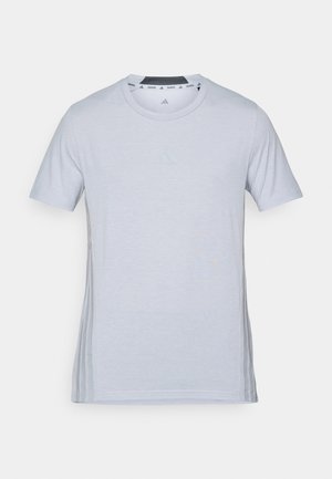 Világosszürke sportpóló rövid ujjakkal, kerek nyakkivágással és diszkrét logóval az elején. Puha anyag, sima textúra és oldalsó díszítések.