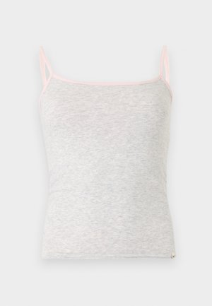 Helehall naiste kampsun õhukeste roosade õlapaelte ja roosa äärega kaeluse ümber tavalisel taustal.