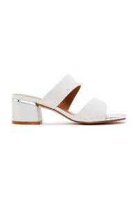 Sandales à talons carrés en cuir blanc avec deux larges brides, un accent argenté brillant sur le talon, et une semelle intérieure lisse couleur tan pour le confort.