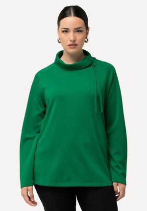 Felpa verde con colletto alto, maniche lunghe e vestibilità rilassata. Presenta un dettaglio decorativo con nodo sulla spalla sinistra. Texture morbida.