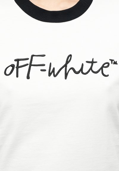 Άσπρο βαμβακερό t-shirt με μαύρο ριμπ λαιμόκοψη, διακοσμημένο με έντονη μαύρη κεντητική που αναγράφει το όνομα της μάρκας «OFF-white™» σε casual καλλιγραφικό στυλ.