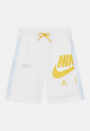 Białe szorty Nike Air z żółtym logo na prawej nogawce, żółtym sznurkiem w pasie oraz jasnoniebieskimi siateczkowymi paskami po bokach.