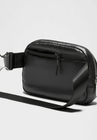 Fekete nylon keresztpántos táska sima textúrával, cipzáras záródással és állítható pánttal. Fém csattal és diszkrét szövéssel díszített.