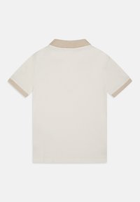 Polo tričko s krátkým rukávem v off-white barvě z bavlny, s béžovým límečkem a manžetami. Hladká textura s klasickým střihem.