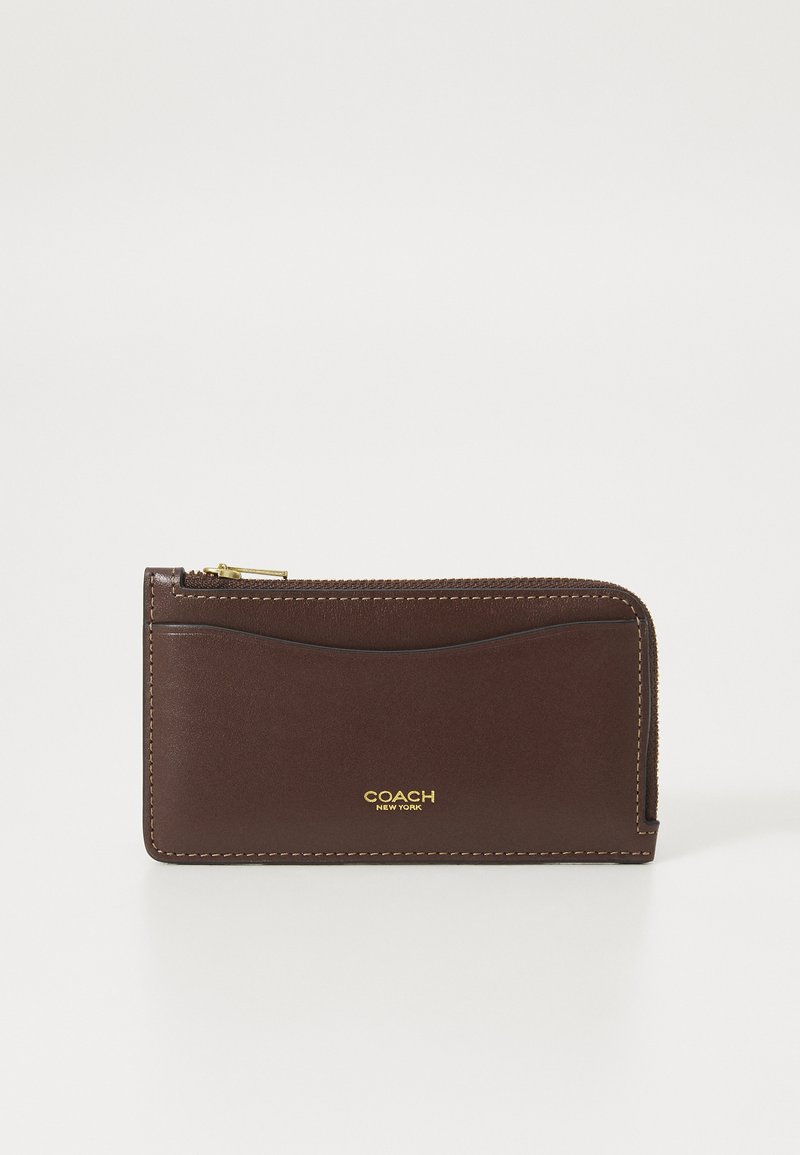 Brown leather wallet with a smooth texture, gold hardware detailing, zip closure, and embossed logo on the front. Compact rectangular shape.