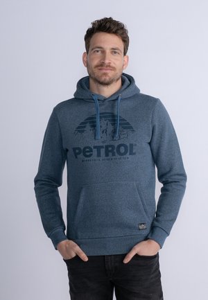 Blauwe hoodie van zacht materiaal met een kangoeroe-pocket, trekkoorden en een donker grafisch ontwerp met het woord "PETROL."