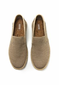 Zapatillas sin cordones con un upper de tela trenzada marrón texturizada, plantilla de corcho y suela de fibra natural. Diseño minimalista con paneles elásticos a los lados.
