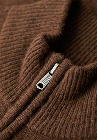 Maglione a coste marrone con zip, dotato di una cerniera argentata e un colletto alto. Materiale texturizzato simile alla lana.