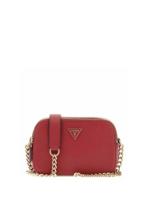 Sac bandoulière rouge Guess avec sangle chaîne dorée et plaque logo triangulaire à l'avant, forme rectangulaire aux bords arrondis avec fermeture éclair.